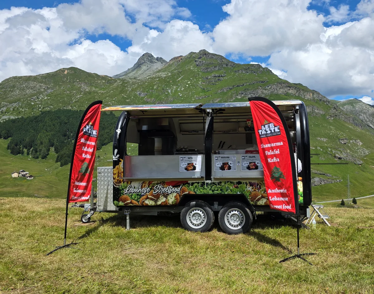 Man sieht einen Foodtruck in den Bergen.